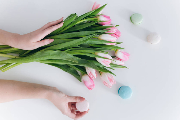 handen met tulpen en macaron - Foto, afbeelding
