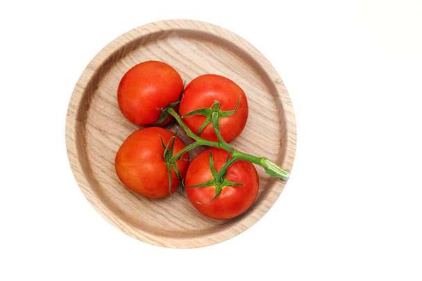 racimo de tomates rojos aislados sobre un fondo blanco. vista plate.top de madera
. - Foto, Imagen
