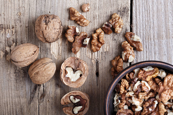 walnuts in a bowl on a wooden background - Photo, image