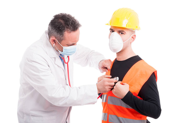 Arzt hört Bauarbeitern mit Stethoskop zu - Foto, Bild