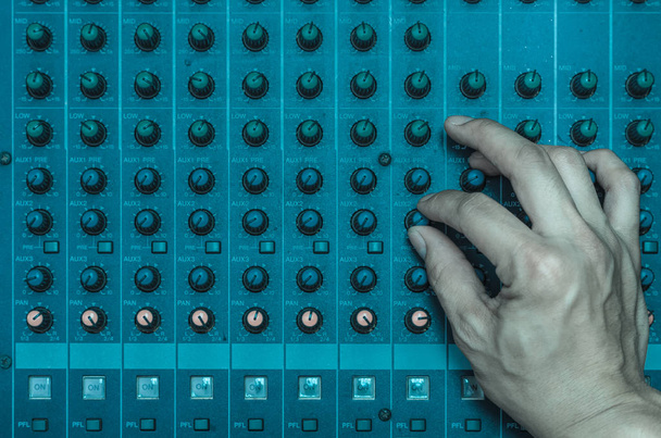 Hand adjusting audio mixer - Foto, afbeelding