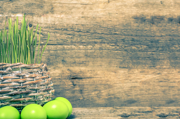 Easter eggs and basket of grass, fresh green wheat, holiday symb - Photo, image