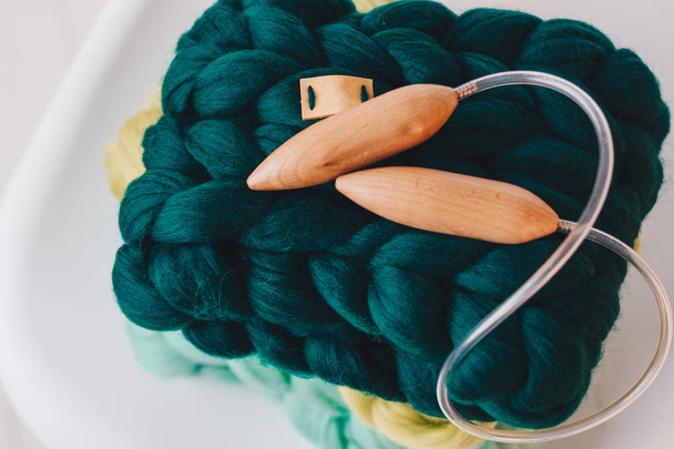 Agulhas de tricô de madeira e lenço verde de lã merino
 - Foto, Imagem