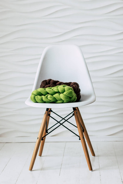 Colorful knitted merino wool scarves on white chair - Foto, afbeelding
