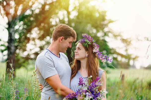 hermosa pareja joven en el jardín de primavera con un ramo de flores silvestres
 - Foto, imagen