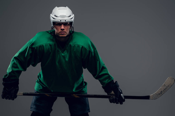 Хоккеист держит ледяную клюшку
 - Фото, изображение