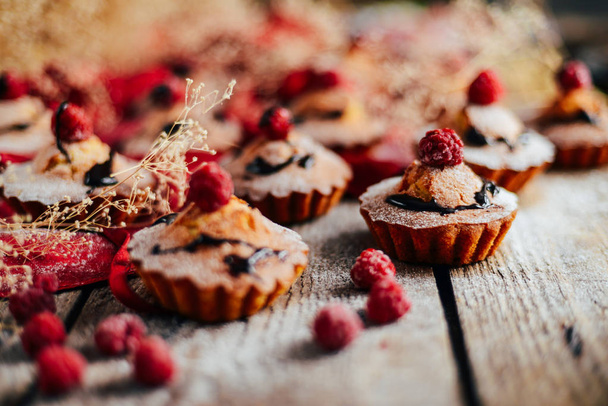 Heerlijke chocolade cupcakes met bessen op wodeen tafel, top v - Foto, afbeelding