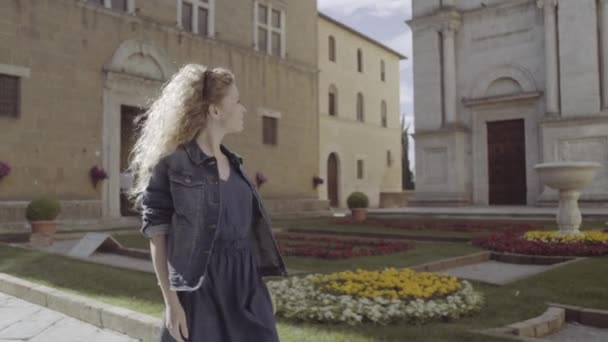Young adult walking through piazza - Felvétel, videó