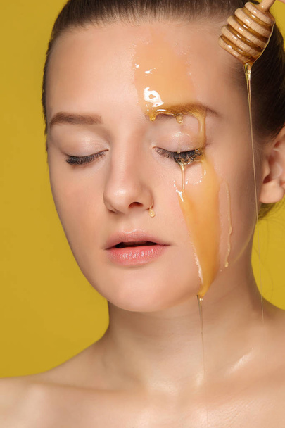 Beautiful woman with honey on her face - Photo, Image