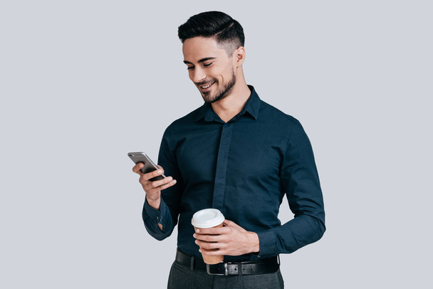 man holding mobile phone and coffee mug - Zdjęcie, obraz