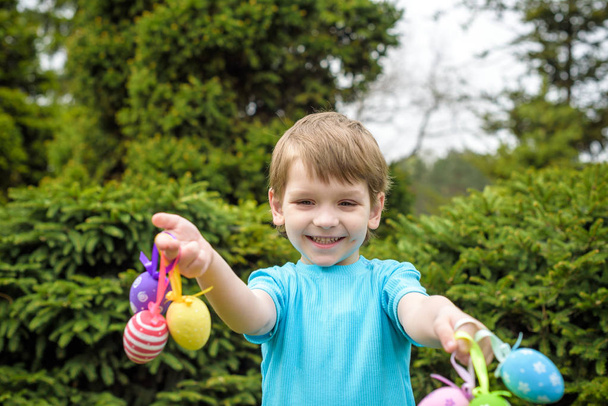 Oeufs de Pâques de différentes couleurs dans les mains d'un enfant- chasse aux œufs
 - Photo, image