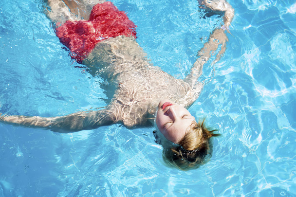 Teen relaxes in the pool - Photo, Image