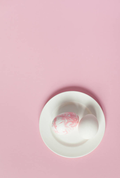 Valkoinen pääsiäismunat valkoisella levyllä vaaleanpunaisella taustalla
 - Valokuva, kuva
