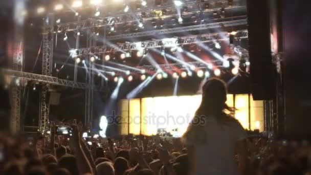 Aufgeregtes Publikum genießt Konzert, Menschen springen und winken bei Musikshow - Filmmaterial, Video