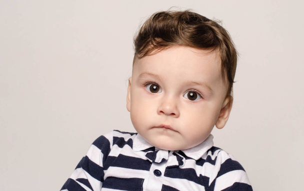 Portrait of a cute baby boy looking at camera with his big eyes. - Fotografie, Obrázek