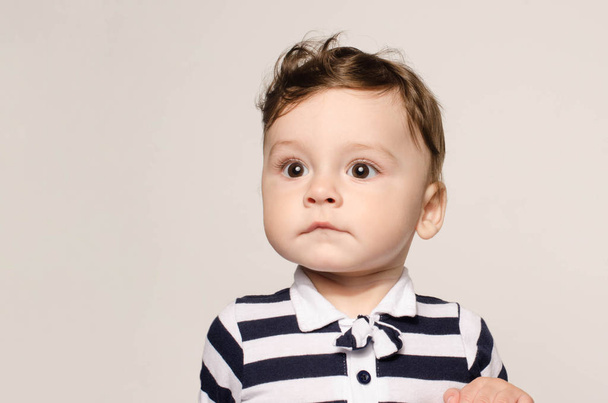 Portrait of a cute baby boy looking away surprised with his big eyes. - Foto, immagini