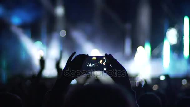 Ręce osoby biorąc zdjęcie pop Star wykonywania na scenie, tłum, brawo - Materiał filmowy, wideo