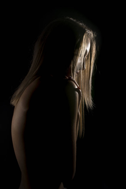 Beautiful young woman hiding in he shadows  - Φωτογραφία, εικόνα