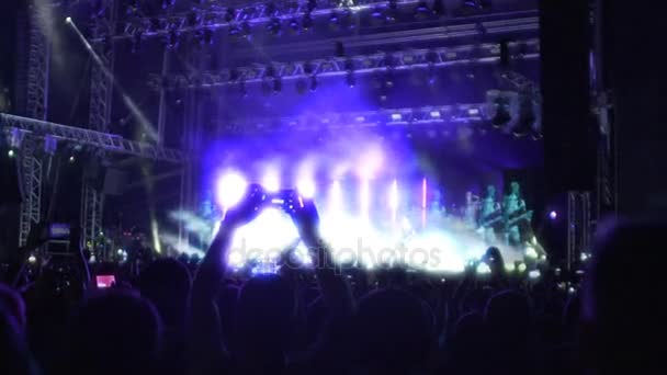 fantastische Musikshow auf beleuchteter Bühne, Silhouetten des Publikums beim Zuschauen - Filmmaterial, Video