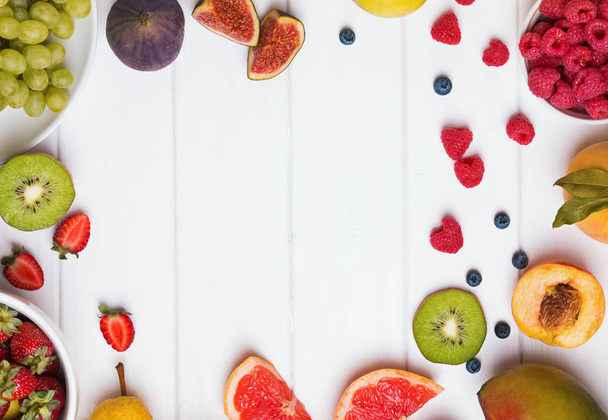Fruits and berries on the white wooden table - 写真・画像