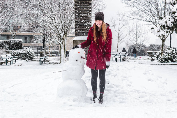 Κορίτσι και χιονάνθρωπος σε False Creek στο Βανκούβερ του Καναδά π.χ. - Φωτογραφία, εικόνα