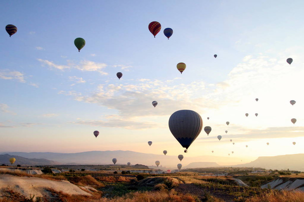 The sunrise in the mountains with a lot of air hot balloons in the sky. - Fotoğraf, Görsel