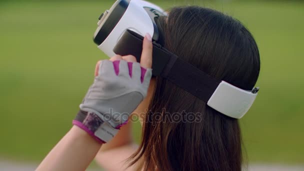 Kobieta przy użyciu zestaw wirtualnej rzeczywistości w parku. Azjatyckie kobiety noszenie okularów Vr - Materiał filmowy, wideo