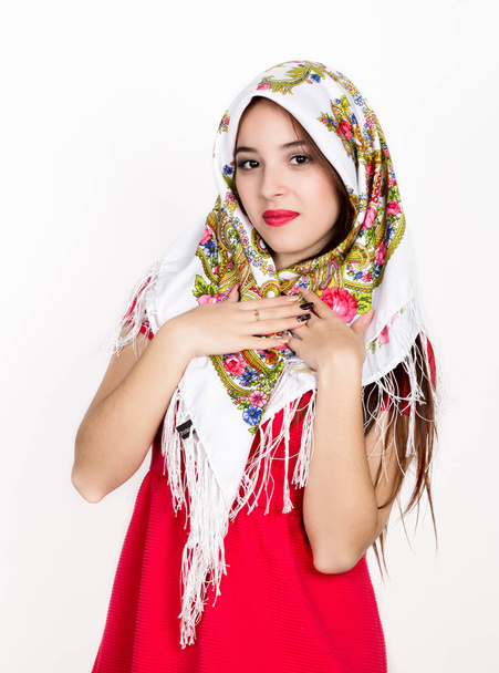 beautiful young woman dressed in a red dress and colored scarf posing in studio - Photo, image