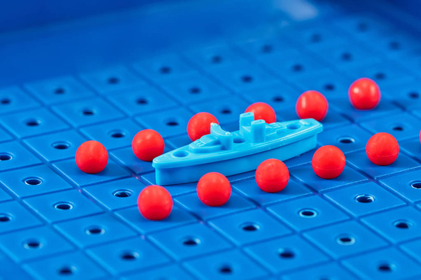 Toy πολεμικό πλοίο που περιβάλλεται από ένα διάδρομο με υποβρύχια νάρκες - Φωτογραφία, εικόνα