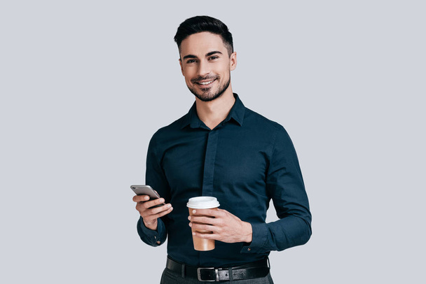man holding mobile and coffee mug - Foto, Imagem