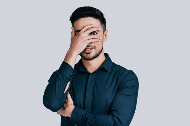 man in casual wear covering face - Foto, afbeelding