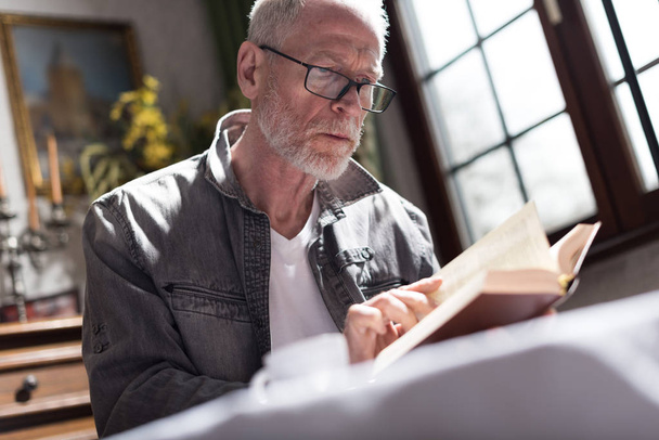 Homem lendo um livro, efeito de luz dura
 - Foto, Imagem