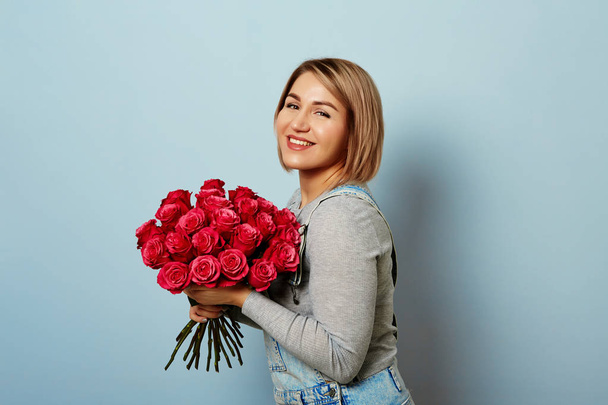 Beautiful girl in the overalls with red roses  - Foto, immagini