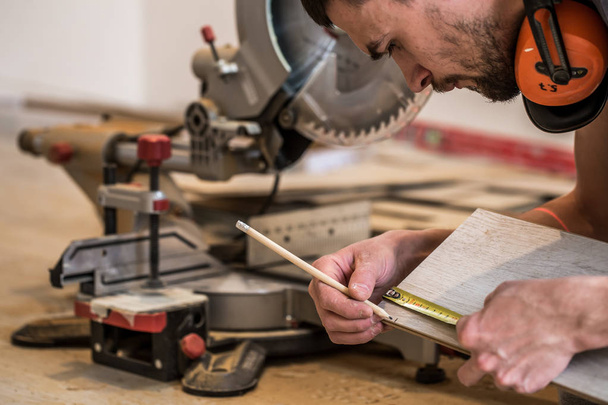 a man working with a miter saw - Φωτογραφία, εικόνα