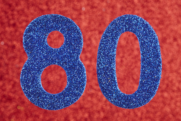 Číslo osmdesát modrá barva nad červeným pozadím. Výročí.  - Fotografie, Obrázek