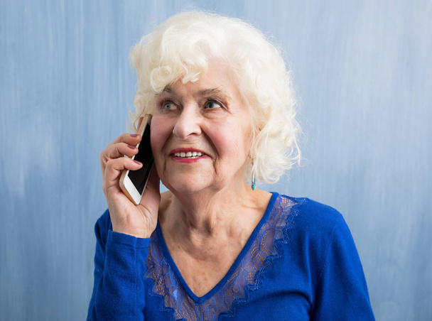 携帯電話で話す高齢女性 - 写真・画像