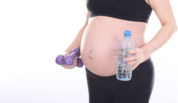 Schwangere übt Hanteln auf weißem Hintergrund - Foto, Bild