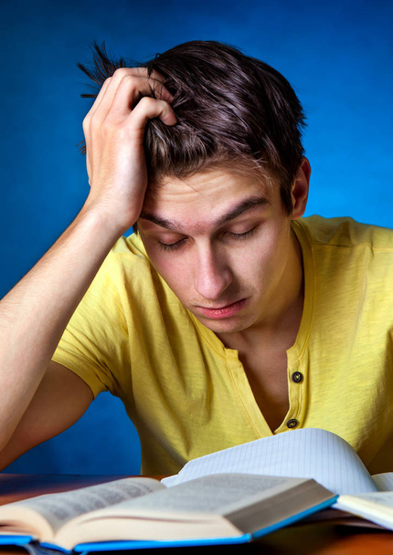 втомлений студент з книгою
 - Фото, зображення