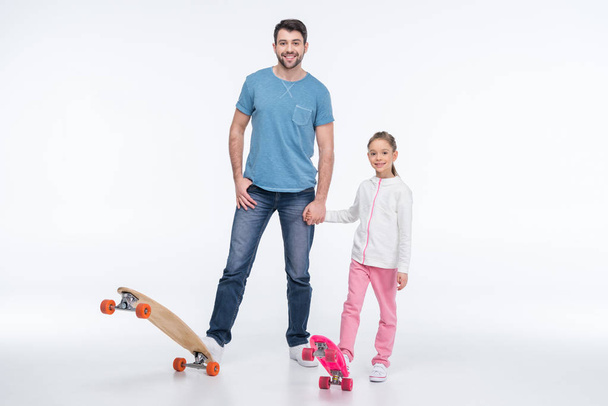 vader en dochter met skateboards - Foto, afbeelding
