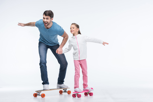 vader en dochter met skateboards - Foto, afbeelding