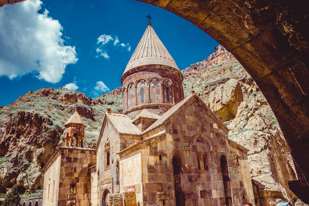 Entrance through tunnel to cave monastery Geghard, Armenia. Armenian architecture. Pilgrimage place. Religion background. Travel concept. Church Astvatsatsin. Tourism industry - Photo, Image
