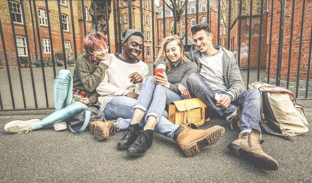 Ryhmä onnellisia monirotuisia parhaita ystäviä, joilla on hauskaa mobiili-älypuhelimella - Nuoret hipsterit, jotka ovat riippuvaisia älypuhelimesta sosiaalisessa verkostoyhteisössä - Teknologian käsite - Elävät tyydyttyneet värisävyt
 - Valokuva, kuva