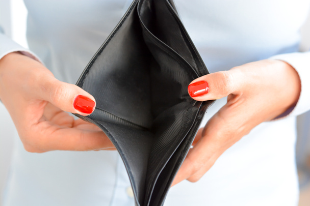 Mujer sosteniendo una cartera vacía sugiriendo bancarrota
 - Foto, Imagen