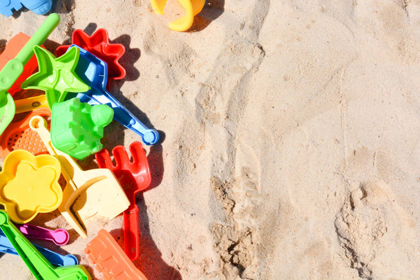 De nombreux jouets de plage colorés posés sur le sable
 - Photo, image