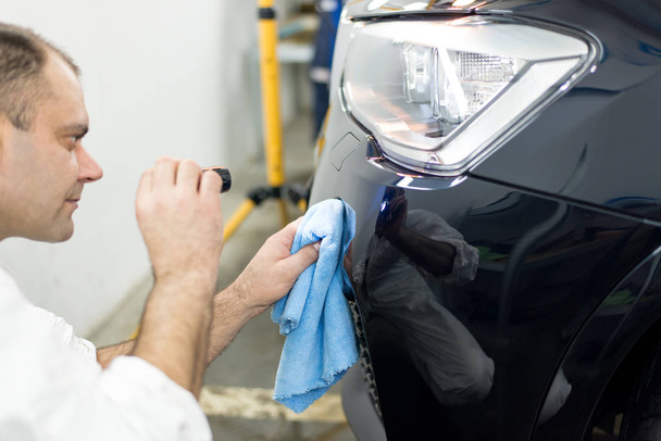 Man on a car wash polishing car with a polish machine - Foto, imagen