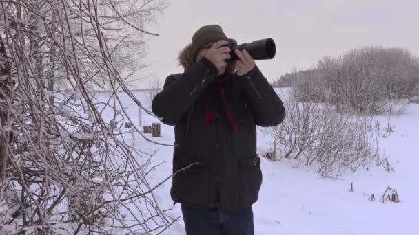 Man take photos on professional photo camera in winter - Footage, Video