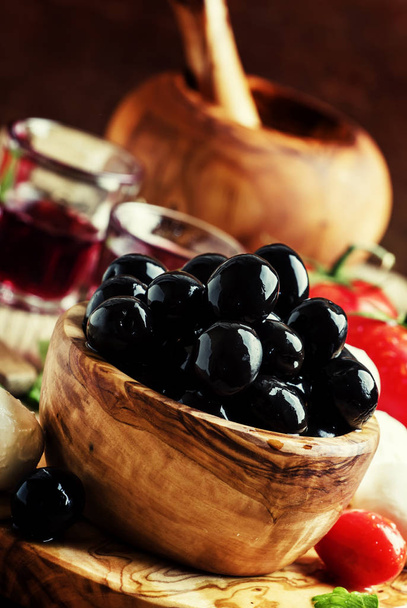 Black olives in a wooden bowl - Φωτογραφία, εικόνα