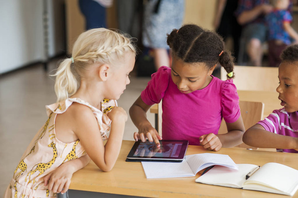 Bambini che usano tablet digitale in classe
 - Foto, immagini
