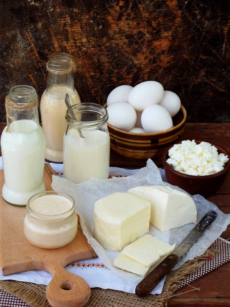 Sada čerstvých mléčných výrobků na dřevěné pozadí: mléko, sýr, cottage, jogurt, vejce, mozzarella, ryazhenka, feta. - Fotografie, Obrázek
