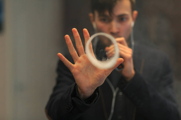 Young handsome white guy let rings out of steam. Vaping. - Foto, Bild